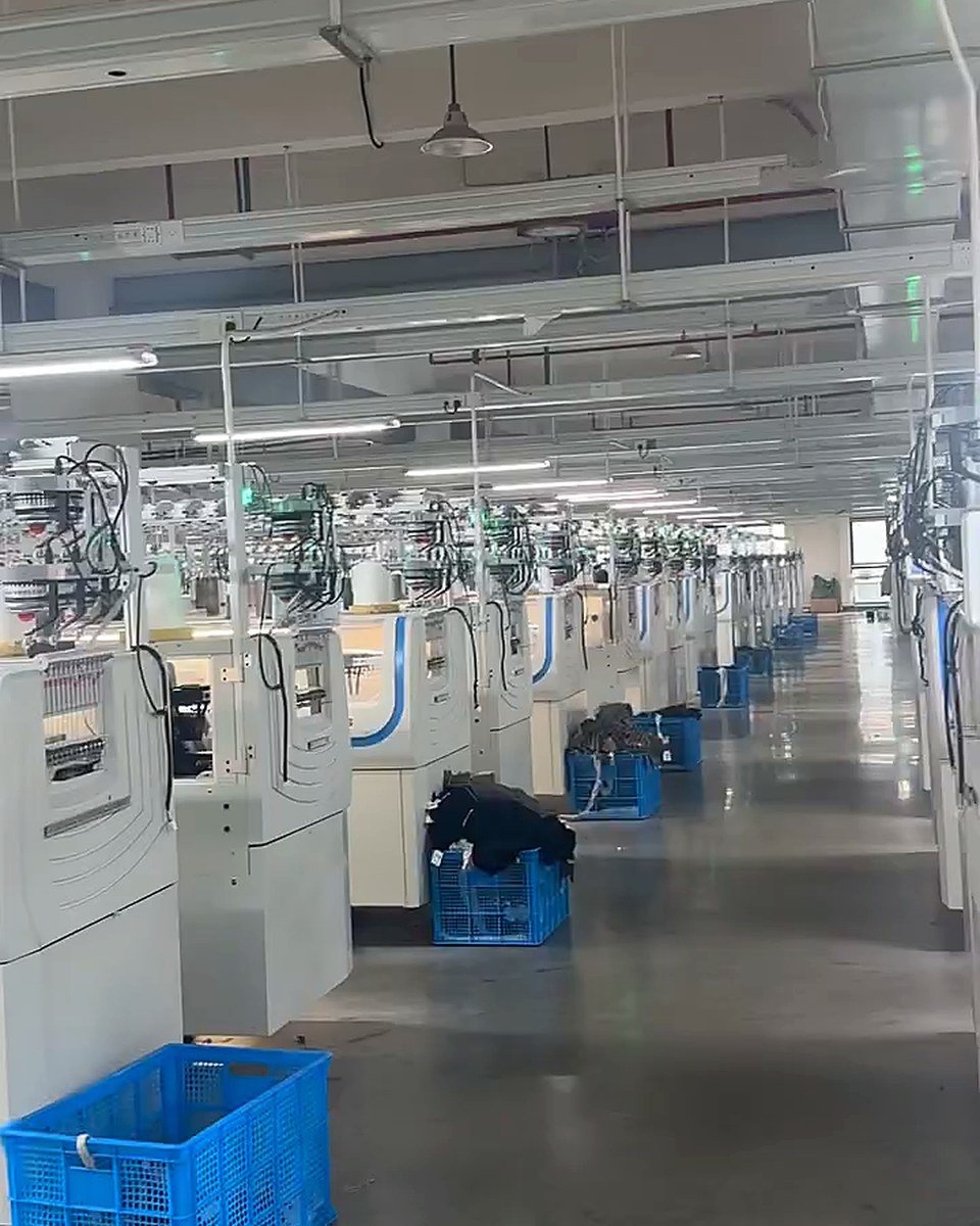 Real factory aisle with rows of 18G seamless knitting machines